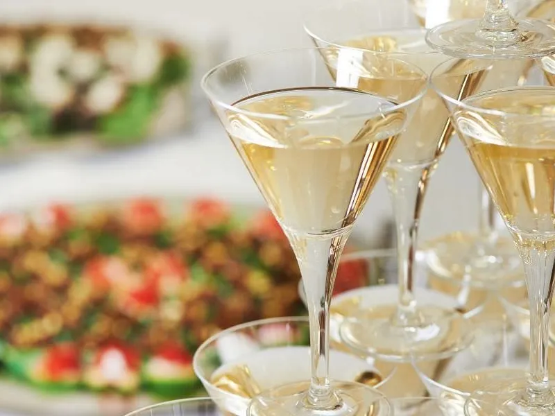 Eröffnungsfeier eines Geschäfts mit Häppchen und Schaumwein