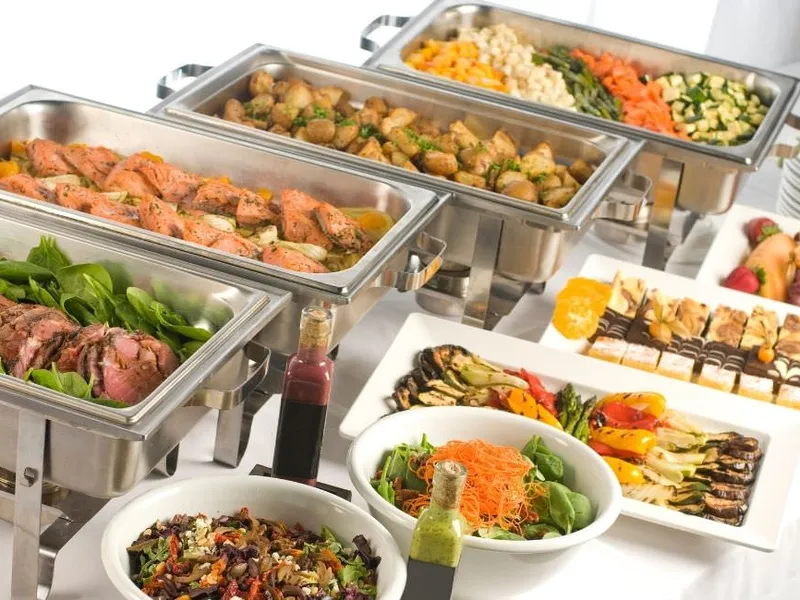 Warmes Buffet mit frisch aufgefüllten Warmhaltebehältern bei einer Feier