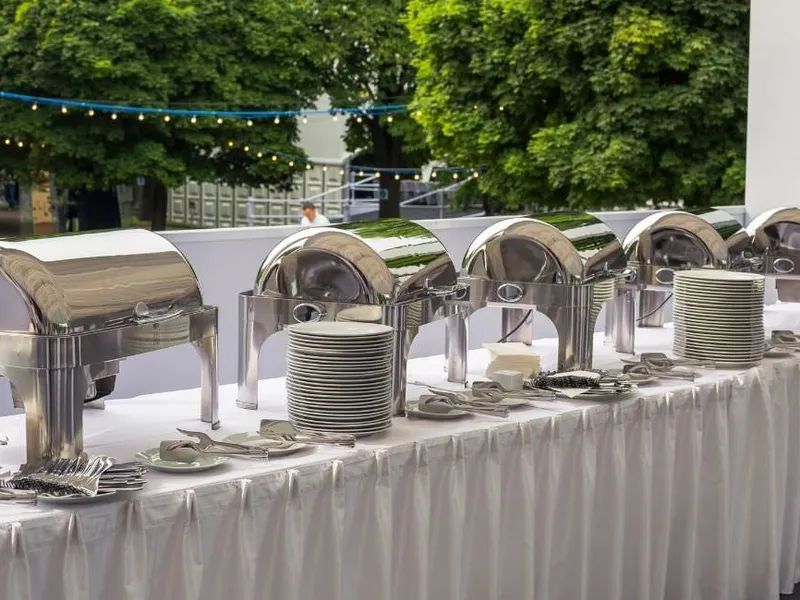 Elegant eingedeckter Tisch mit feinem Besteck und gefalteten Stoffservietten Elegant eingedeckter Tisch mit feinem Besteck und gefalteten Stoffservietten